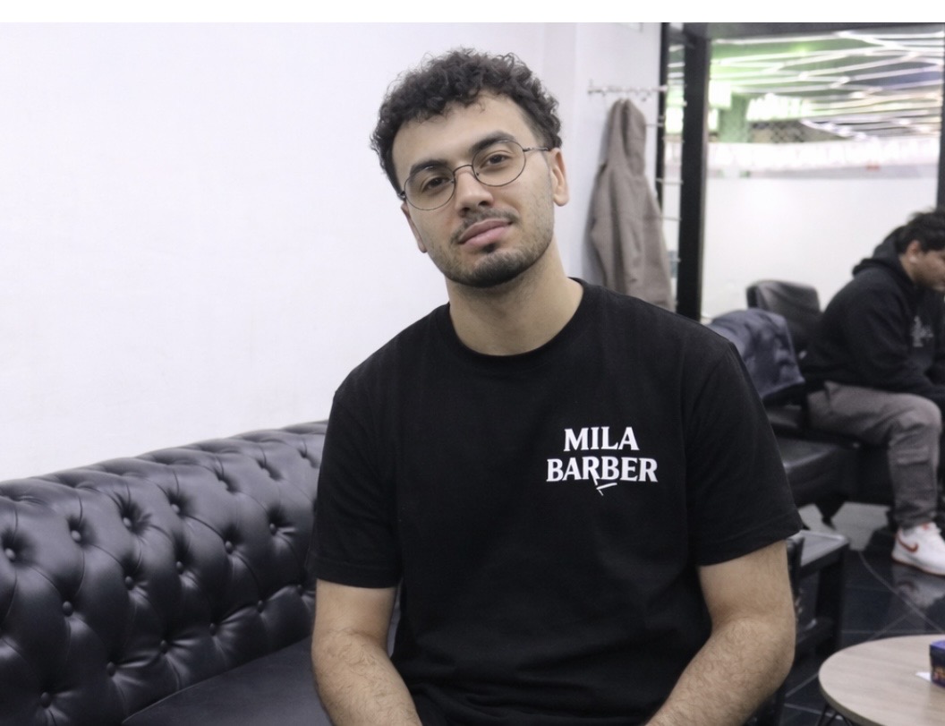 Nassim, sentado en el sofá de la zona de espera de la barbería